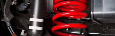 shock spring under a car tire
